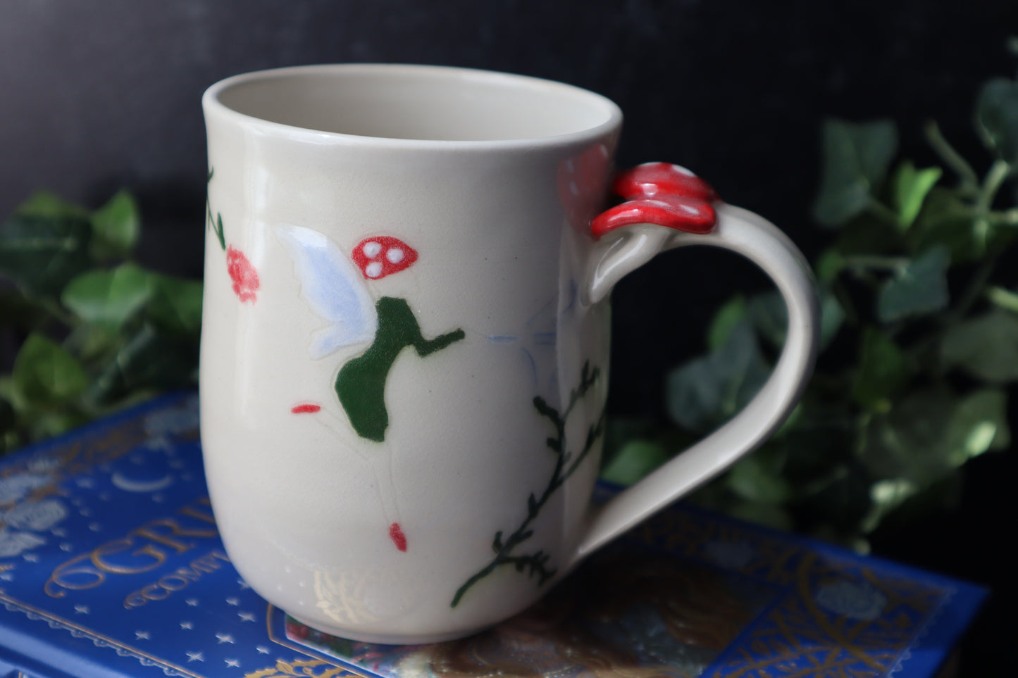 White mug with fairy design on a dark background