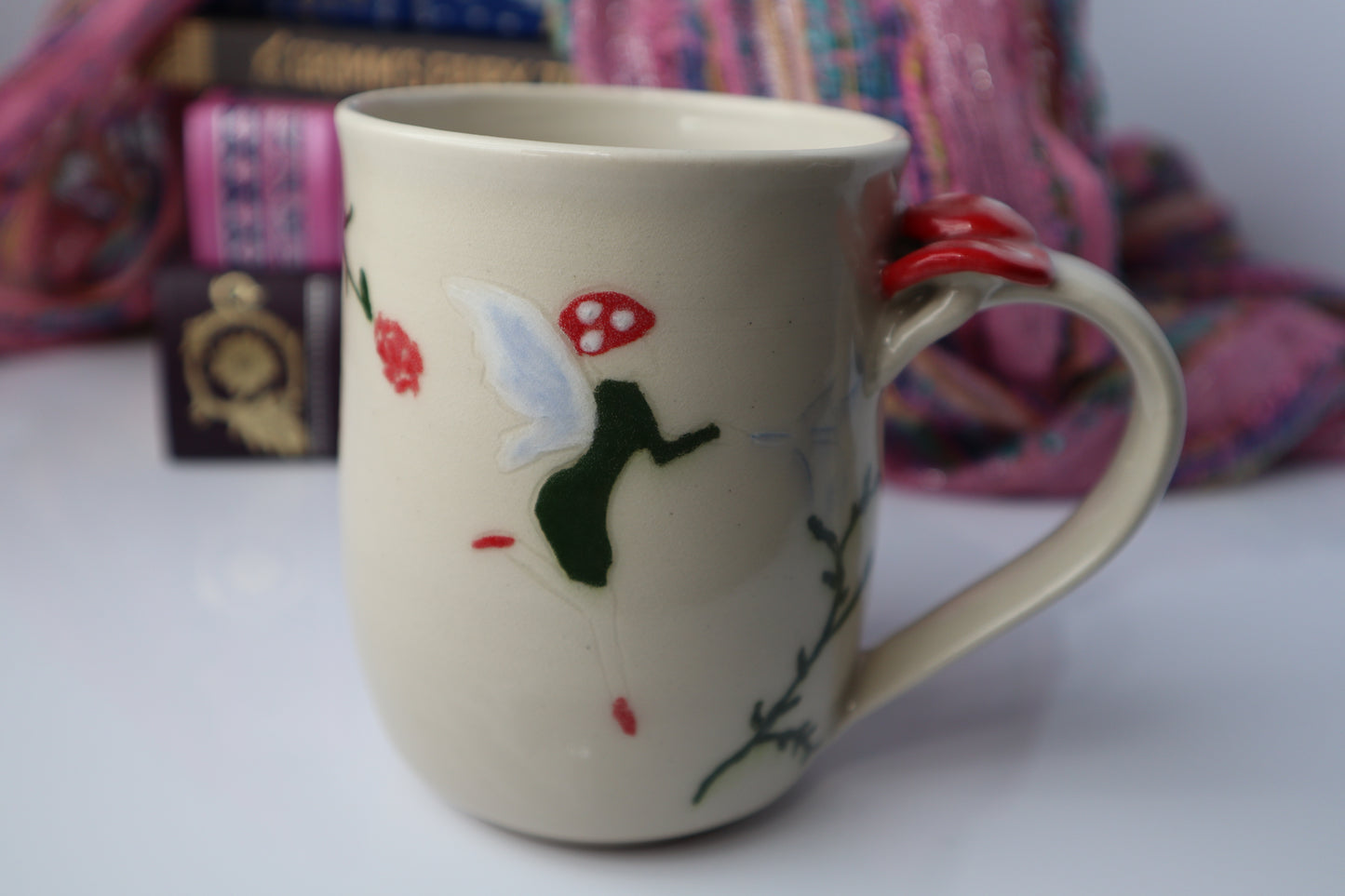 Beige mug with fairy design on a white surface with colorful background