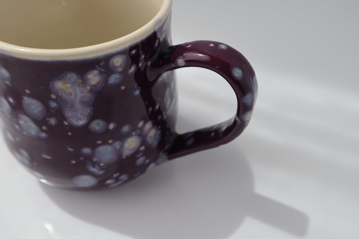 Mug with purple and white speckled pattern on a white background