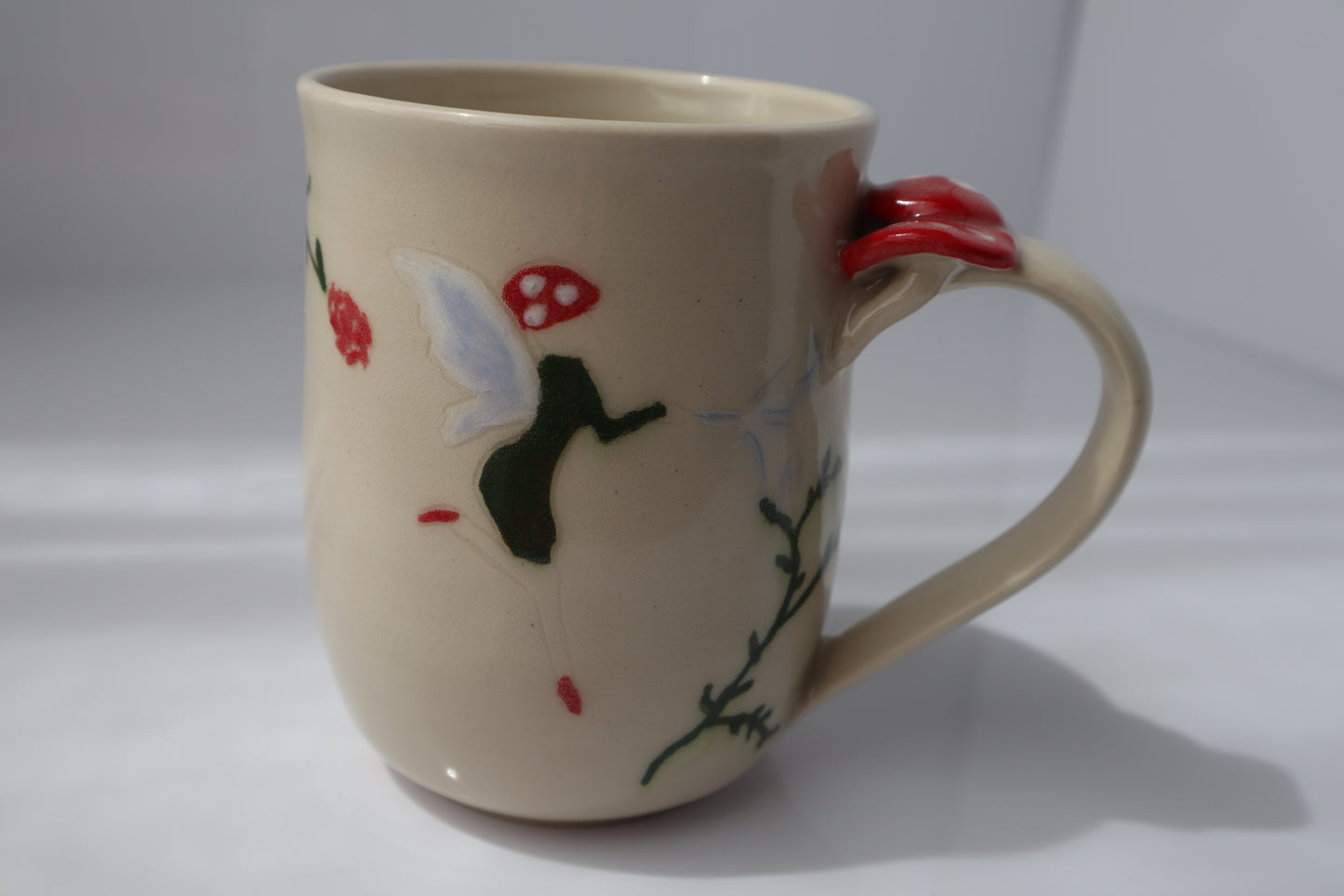 Beige mug with fairy and flower design on a white background