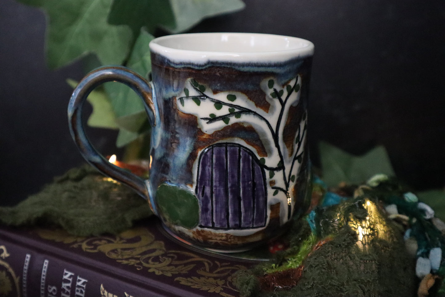 Decorative ceramic mug with a fairy door design on a dark background