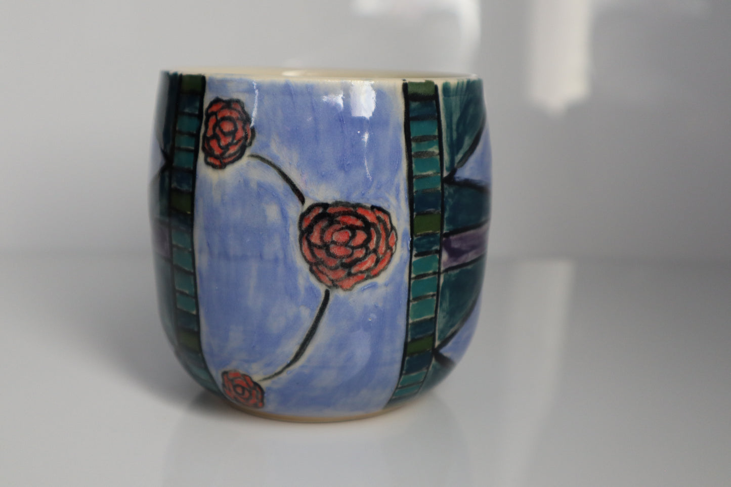 Ceramic cup with floral design on a white background
