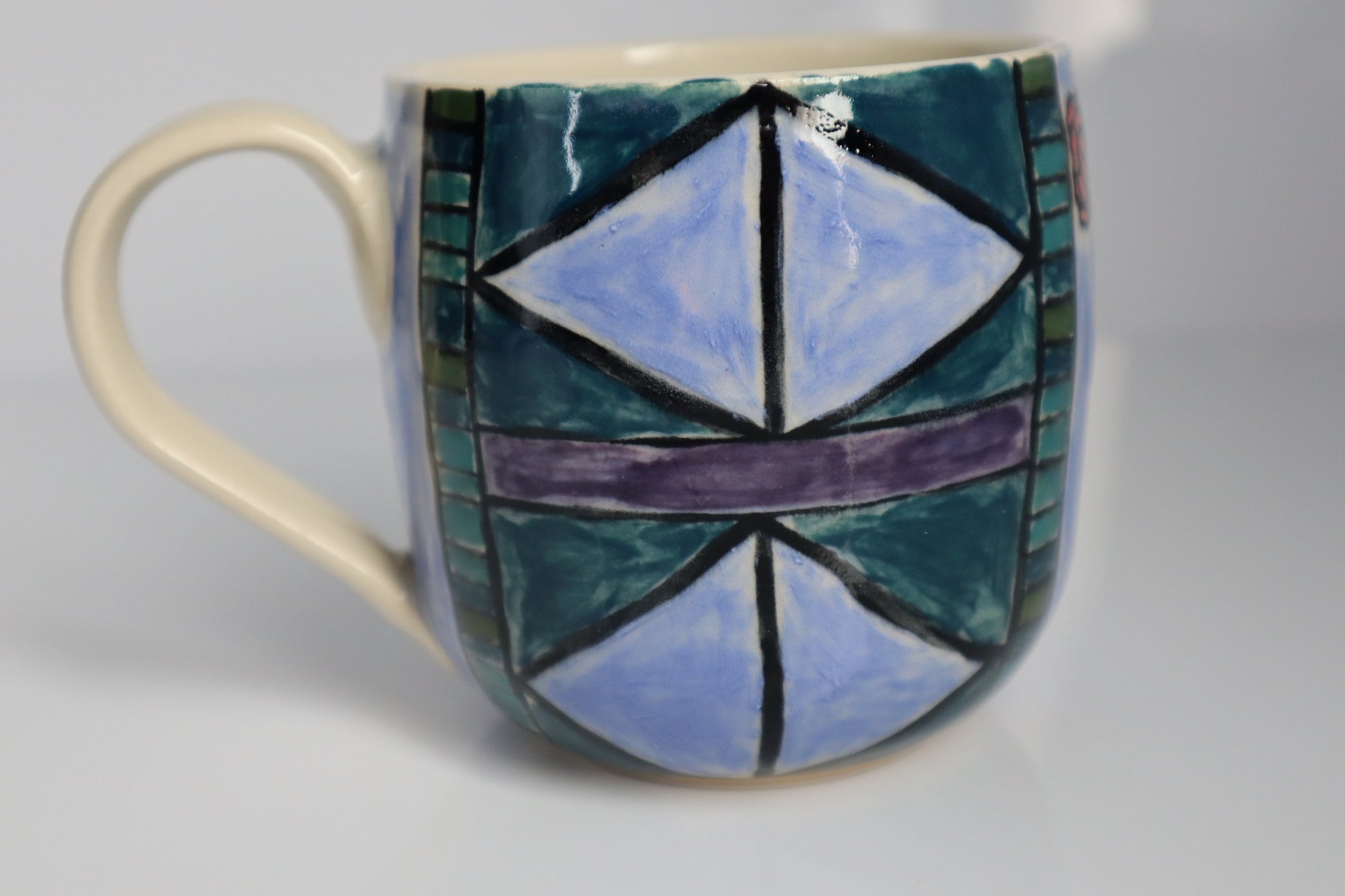 Ceramic mug with geometric design on a plain background