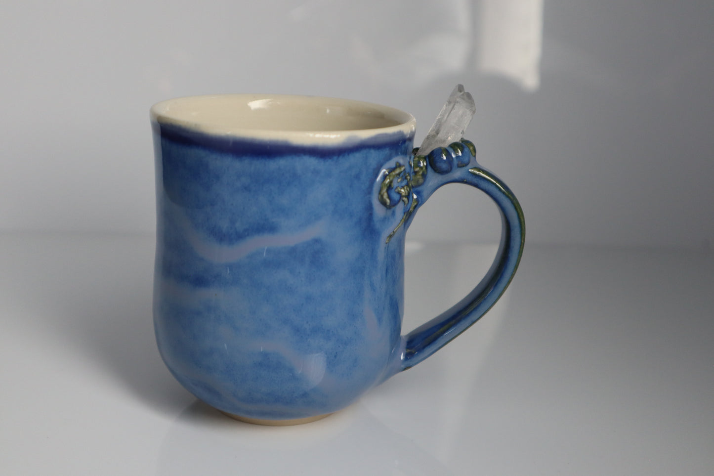 Blue ceramic mug with a handle on a gray background