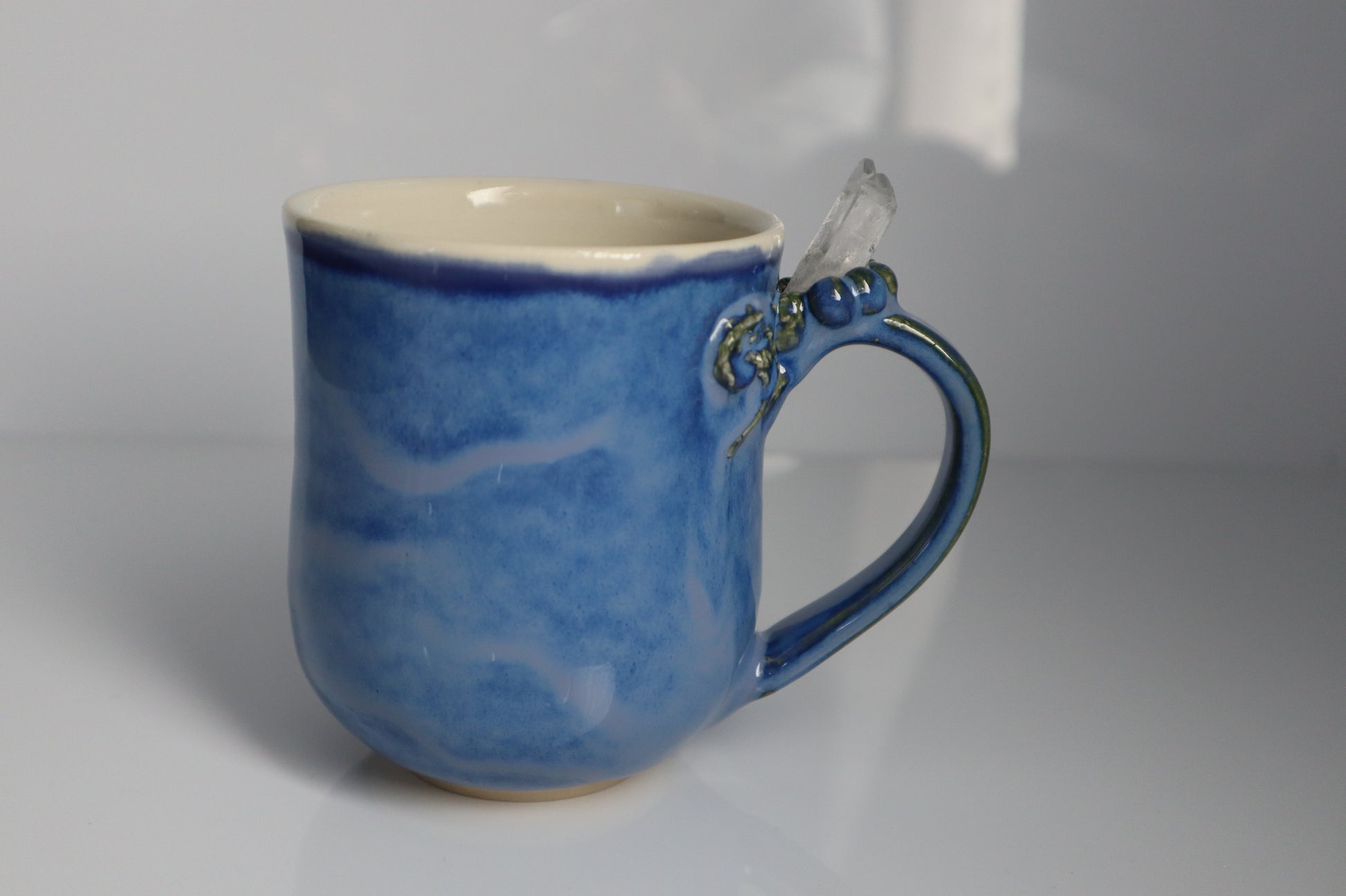 Blue ceramic mug with a handle on a gray background