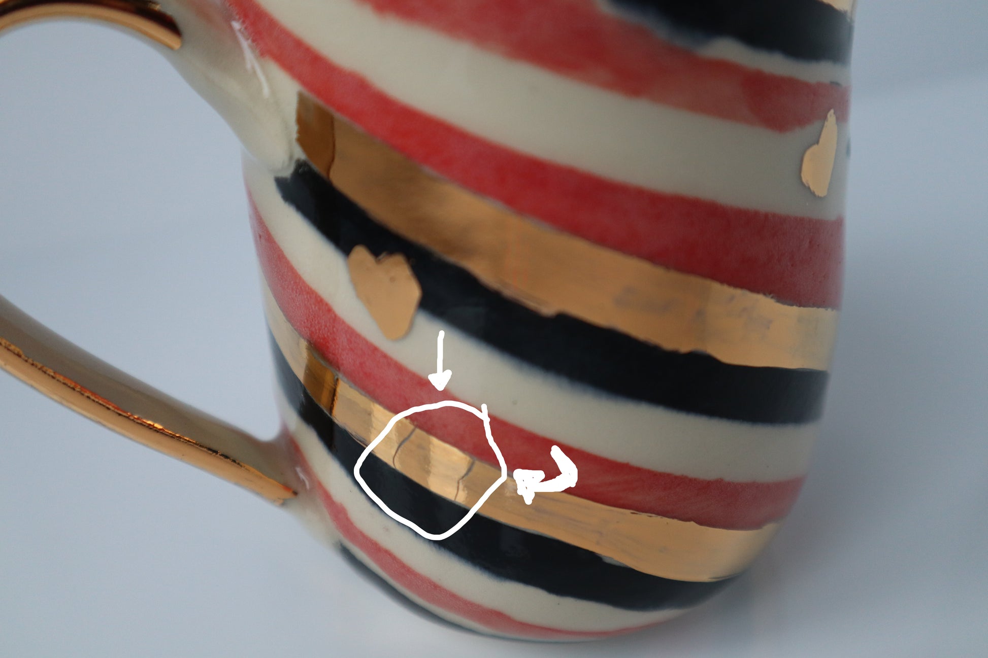 Showing the imperfections in the gold stripes of the mug. Incomplete coverage of the gold