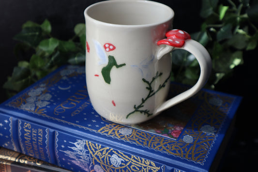 Decorative mug with a fairy design on a blue book with text