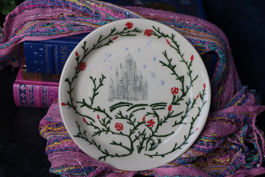 Decorative plate with a castle design on a colorful fabric background