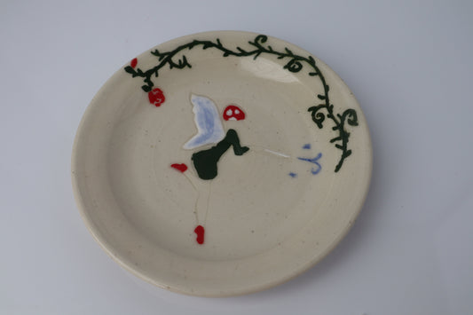 Ceramic plate with fairy on a plain background