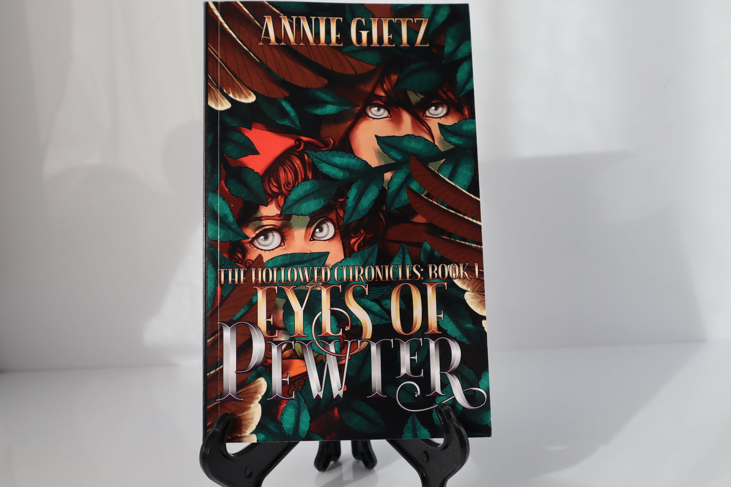 Book titled 'Eyes of Pewter' by Annie Gietz on a stand against a white background.