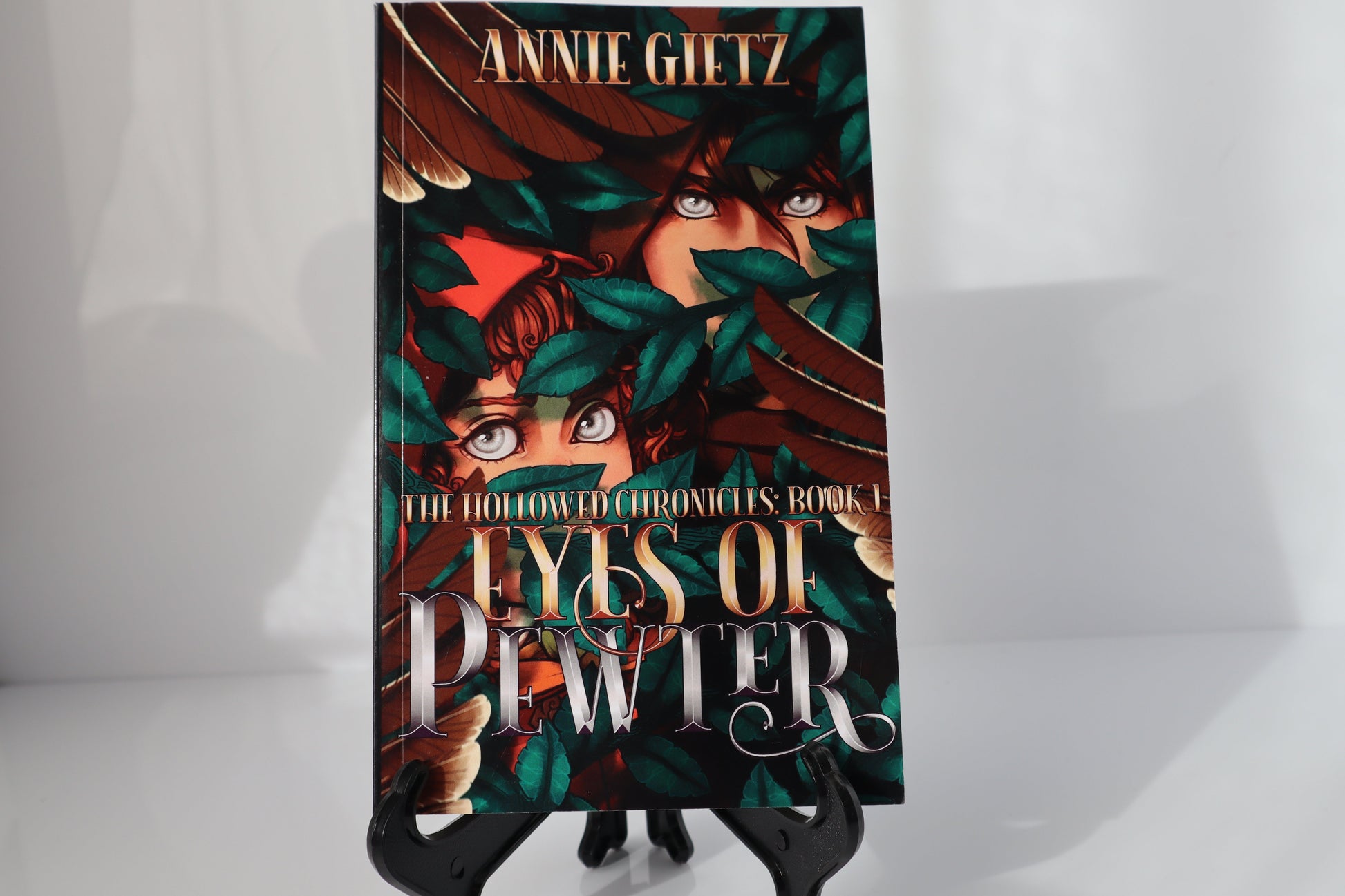 Book titled 'Eyes of Pewter' by Annie Gietz on a stand against a white background.