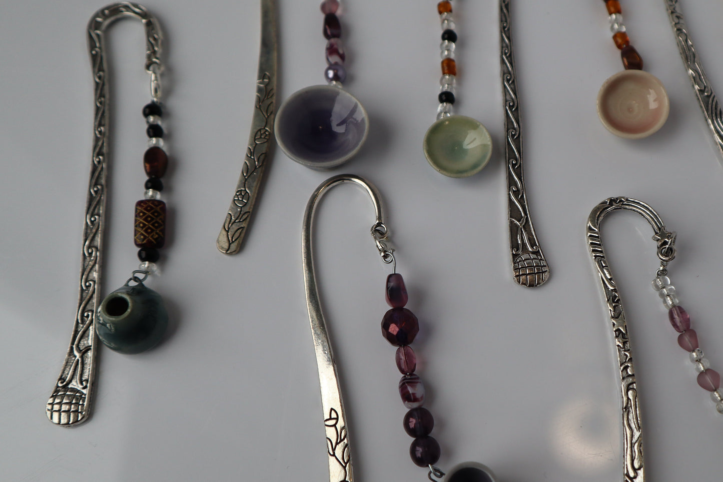 Collection of decorative bookmarks with beads and pottery on a light background