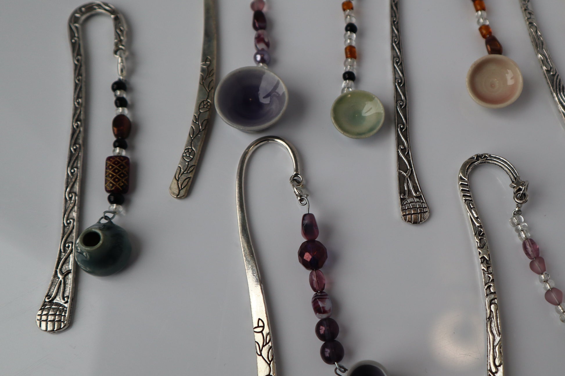 Collection of decorative bookmarks with beads and pottery on a light background