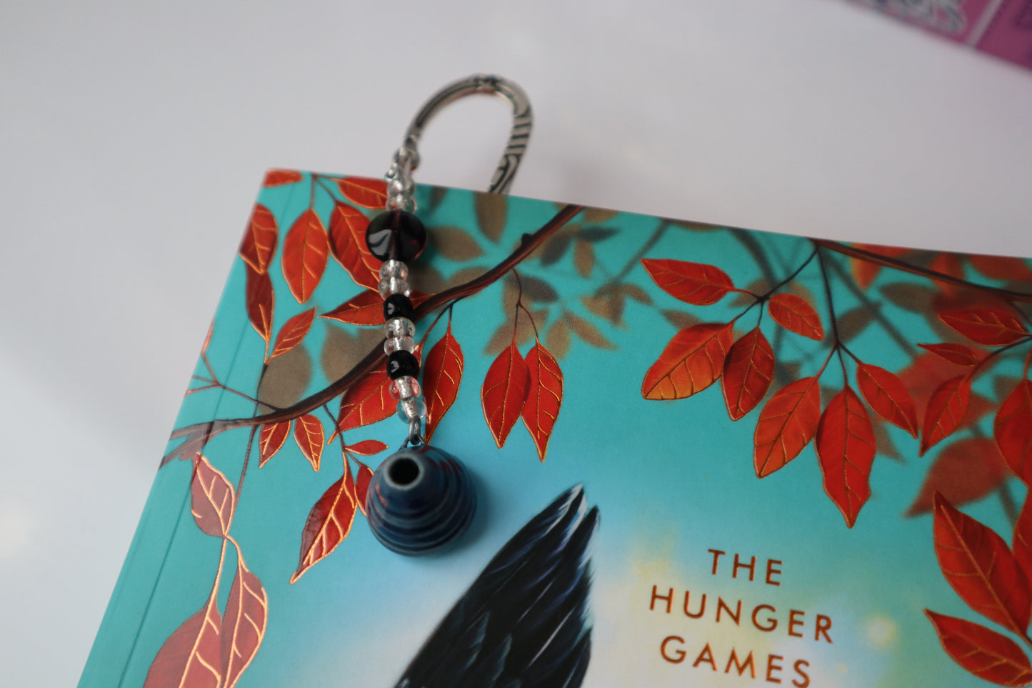 Metal bookmark with beaded pottery charm in a book