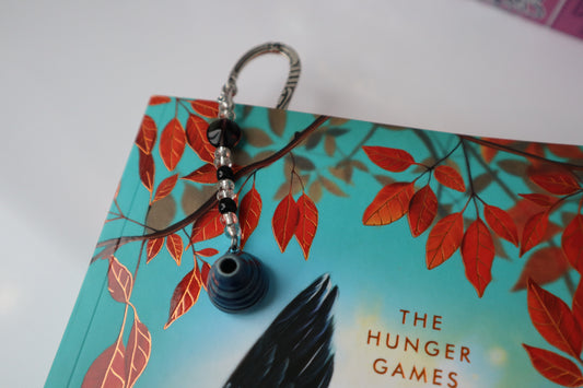 Metal bookmark with beaded pottery charm in a book