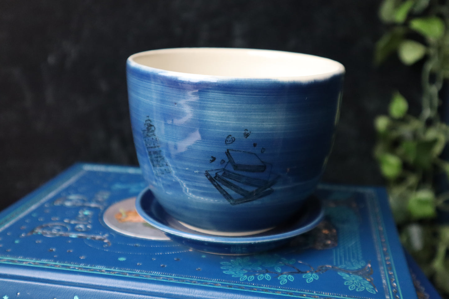 Blue Book Lovers planter sitting on a stack of books.